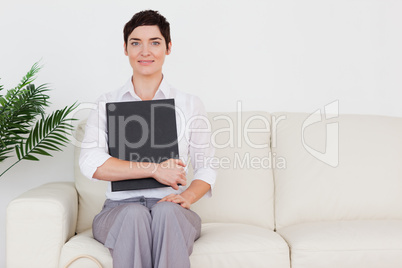 Brunette short-haired woman sitting on a sofa