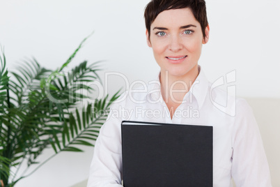 Portrait of a Brunette short-haired woman with a folder