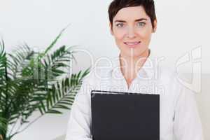 Portrait of a Brunette short-haired woman with a folder