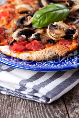 Pizza Funghi auf einem Holztisch