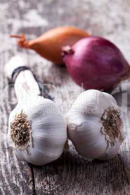 Nahaufnahme von Knoblauch und Zwiebeln auf einem Holzbrett