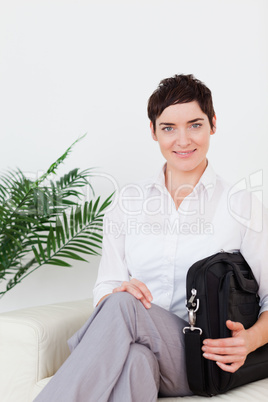 Short-haired smiling businesswoman sitting on a sofa