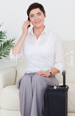Woman with a suitcase and a phone