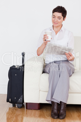 Woman with a suitcase and a phone and a newspaper