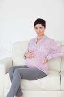 Pregnant woman sitting on a sofa