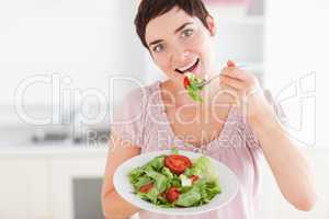 Good-looking woman eating salad