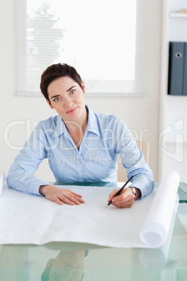 Smiling woman with a architectural plan looking into the camera