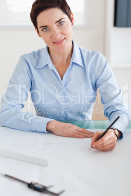 Woman with a architectural plan looking into the camera