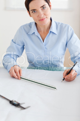 Gorgeous Woman working on an architectural plan looking into the