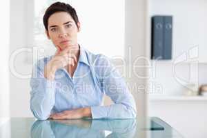 Thoughtful Businesswoman sitting behind a desk