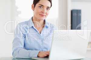 Businesswoman with a laptop looking at the camera