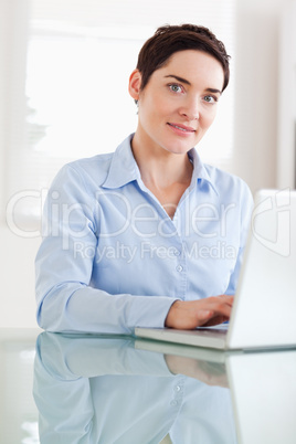 Brunette businesswoman with a laptop looking at the camera