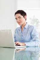 Short-haired businesswoman with a laptop looking into the camera