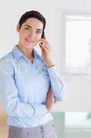 Smiling brunette businesswoman on the phone