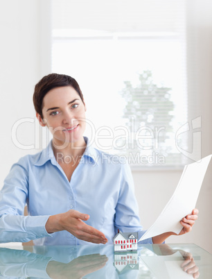 Gorgeous Woman holding papers showing a model house