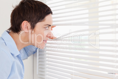 Beautiful woman peeking out a window