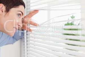 Charming woman peeking out a window