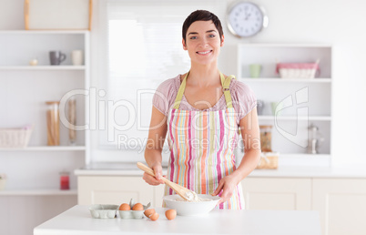 Short-haired brunette woman preparing a cake