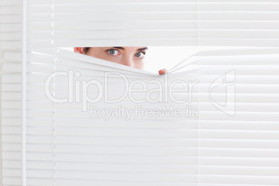 Brunette businesswoman peeking out of a window