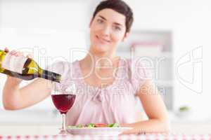 Smiling Woman pouring redwine in a glass