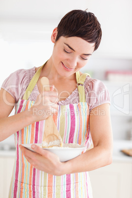 Happy brunette woman preparing a cake