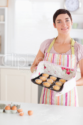 Beautiful brunette woman showing muffins