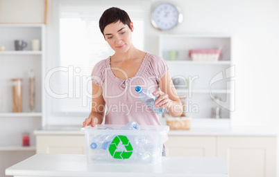 Woman putting bottles in a recycling box