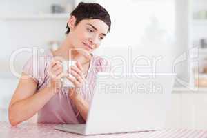 Cute woman with a cup and a laptop