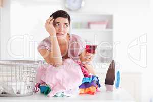 Upset woman with wine and a pile of clothes