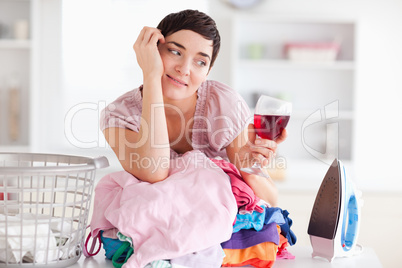 Cute Woman with wine and a pile of clothes
