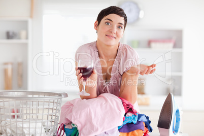 Beautiful Woman with wine and a pile of clothes