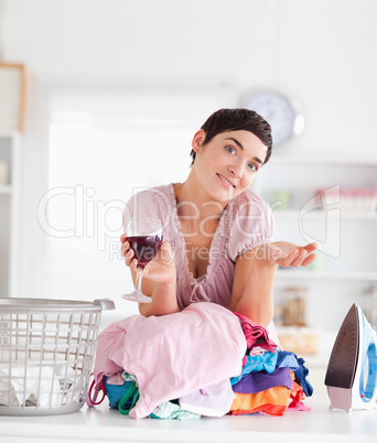 Smiling Woman with wine and a pile of clothes
