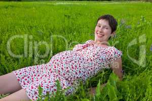 Pregnant woman lie on the grass