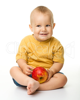 Cheerful little boy with red apple