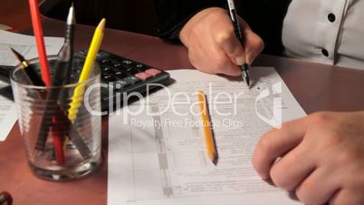 business woman signs her tax form 1040. slider shot.