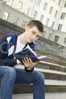Male student on campus with textbooks