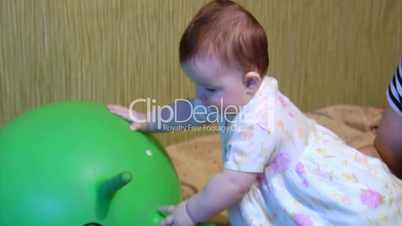 baby playing with green ball