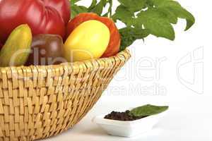 Korb mit frischen Biotomaten und Pfefferkörner Schale / Basket of fresh organic tomatoes and pepper dish