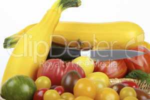 Frische Tomaten und gelbe Zucchinis mit Messer im Korb / Fresh tomatoes and yellow zucchini with a knife in the basket