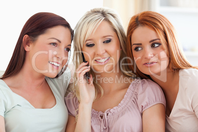 Smiling women sitting on a sofa with a mobile