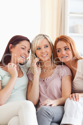 Charming women sitting on a sofa with a mobile