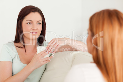 Chatting Women sitting on a sofa with cups