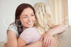 Young women hugging on a sofa