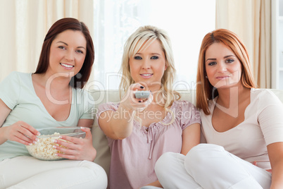 Smiling Women watching a movie eating popcorn