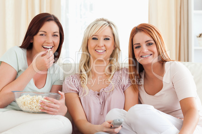 Cheerful Women watching a movie eating popcorn