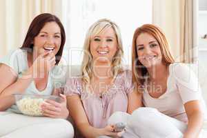 Cheerful Women watching a movie eating popcorn