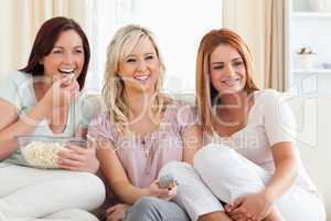 Joyful Women watching a movie eating popcorn