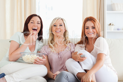 Cheerful Friends lounging on a sofa watching a movie