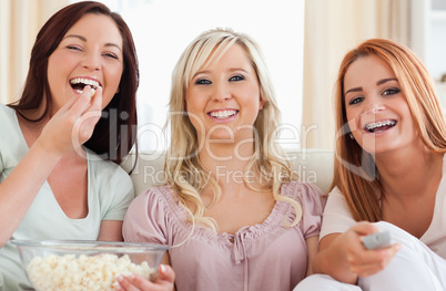 Charming Friends lounging on a sofa watching a movie