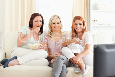 Gorgeous women lounging on a sofa watching a movie